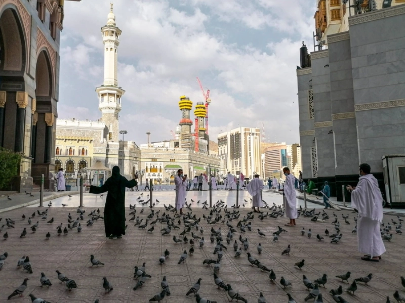 حرص المعتمرون في أول أيام رمضان على إطعام الحمام والتقاط الصور التذكارية (أنس الحارثي)