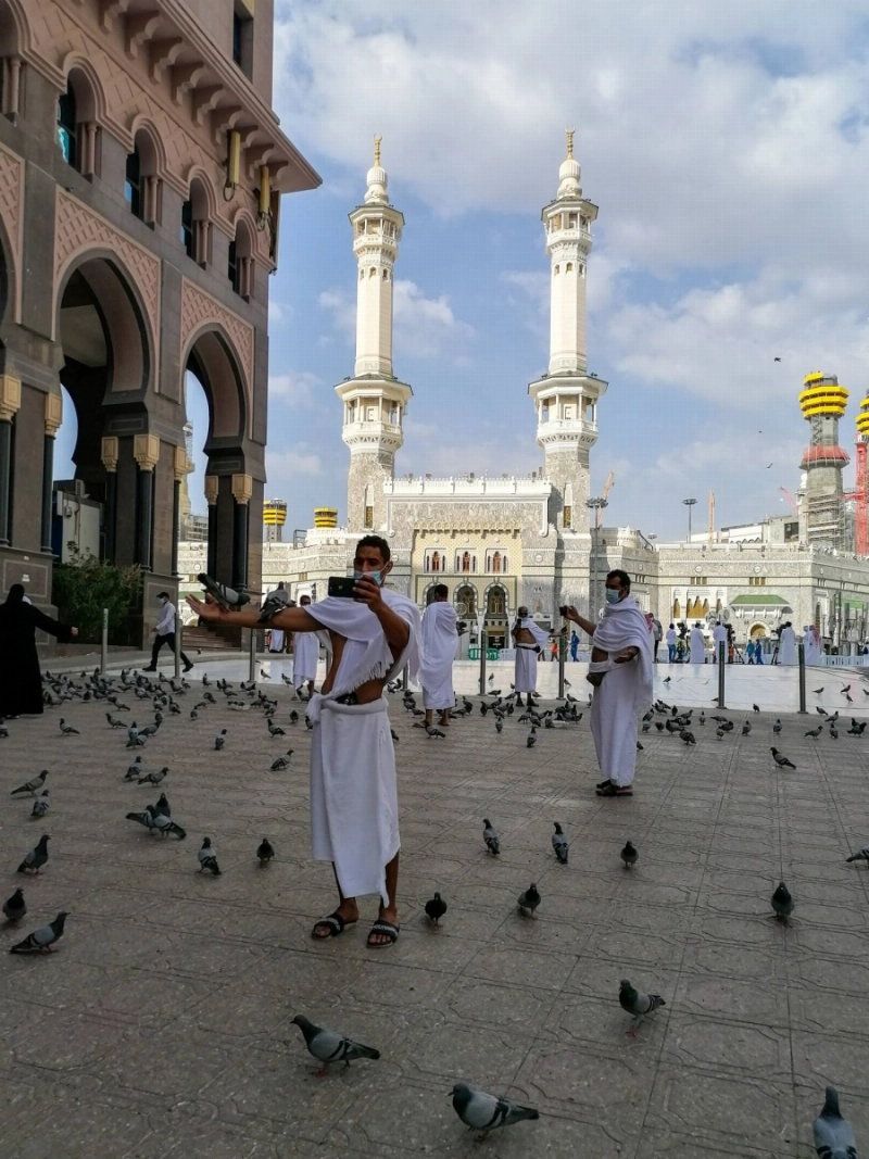 حرص المعتمرون في أول أيام رمضان على إطعام الحمام والتقاط الصور التذكارية (أنس الحارثي)