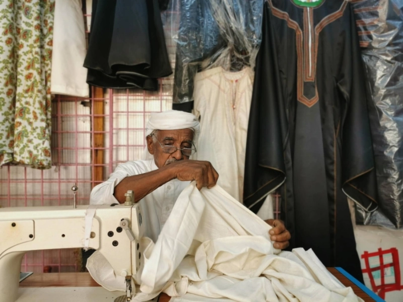 ابن سروان خلال حياكته الزي النجراني القديم (واس)