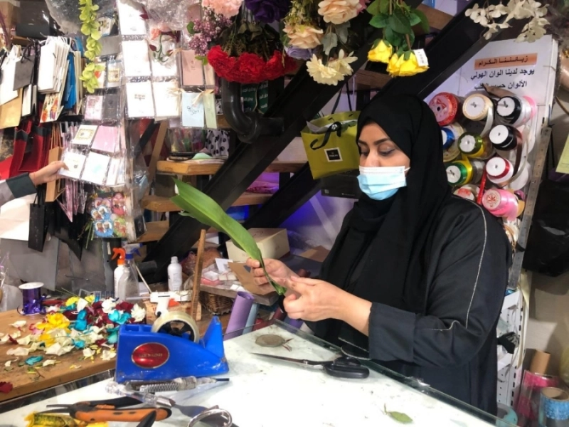 إحدى الفتيات منهمكة في تنسيق الزهور (مكة)