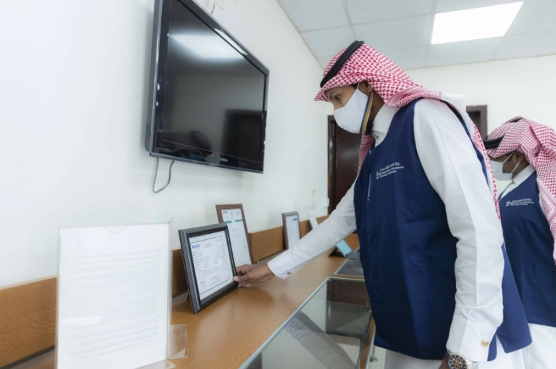 ممثلان لهيئة الاتصالات أثناء جولة على شركة خدمات بريدية