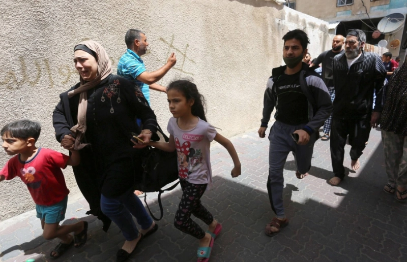 أسرة فلسطينية تخلي مبنى استهدفته الغارات الإسرائيلية (د ب أ)