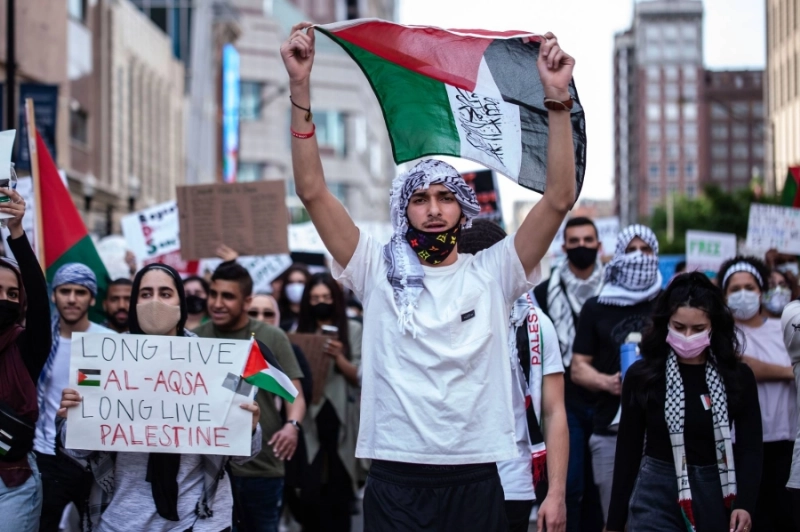 متظاهرون يحملون لافتات تناصر فلسطين (د ب أ)
