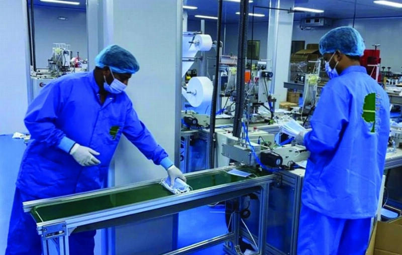 عاملان في مصنع للكمامات (مكة)