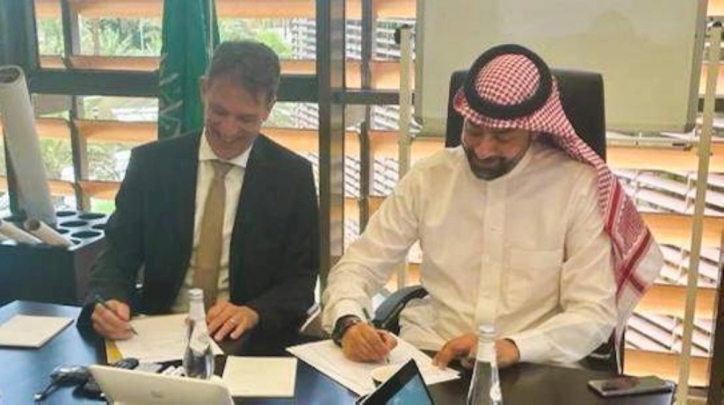 عمرو المدني وكونراد بيسندورفر خلال التوقيع (مكة)