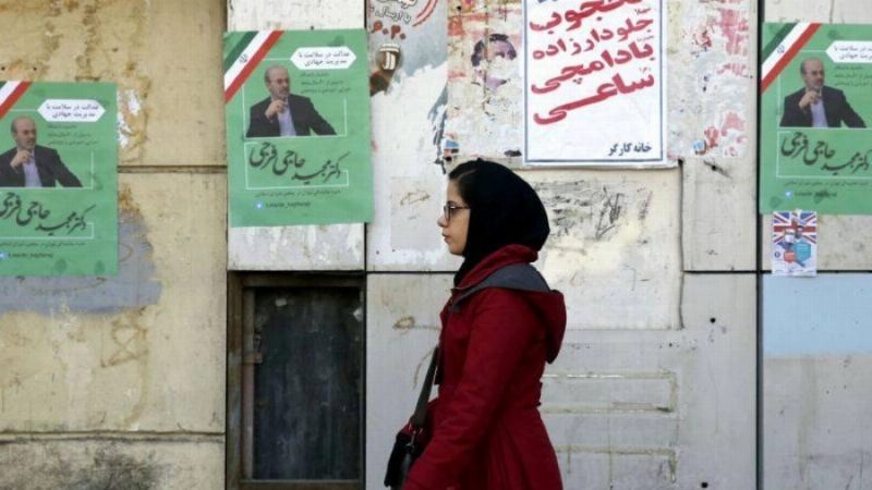 إيرانية تسير أمام «دعايات» انتخابية (مكة)