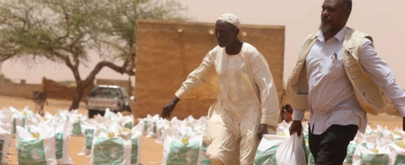 سودانيان يحملان مساعدات مركز الملك سلمان للاغاثة (واس)
