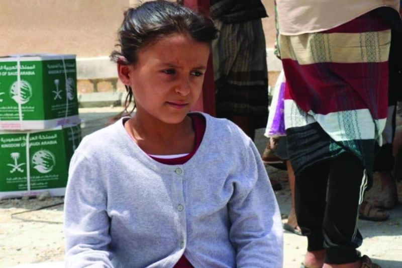 طفلة يمنية خلفها سلال الغذاء السعودية (واس)