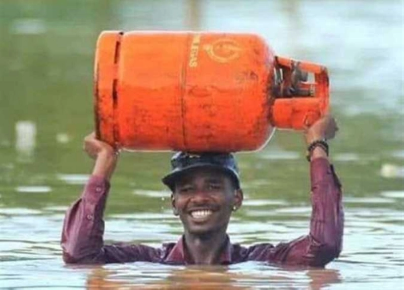 سوداني يخوض في المياه لملء أنبوبة غاز (مكة)