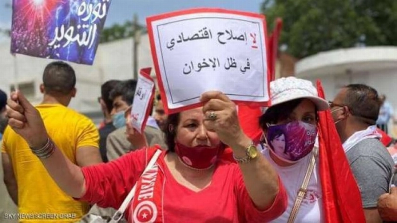 تونسية تحمل لوحة ترفض الإخوان