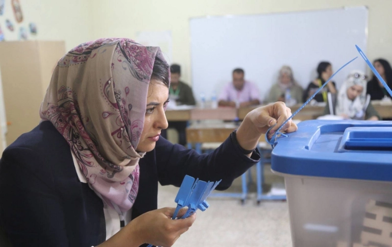عراقية تنظر في أحد صناديق الانتخابات (د ب أ )