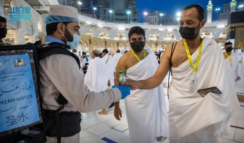 عامل يوزع مياه زمزم بأسطوانة محمولة (مكة)