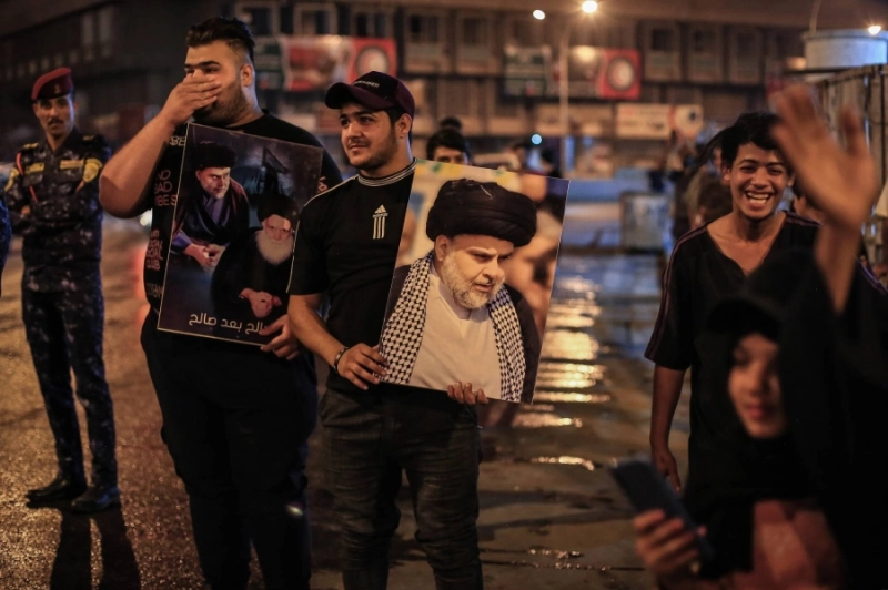 شباب عراقي يحمل صور مقتدى الصدر (د ب أ)