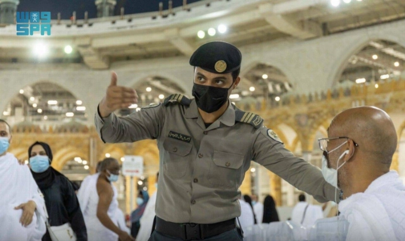 موظف الأمن والسلامة يوجه أحد المعتمرين (مكة)