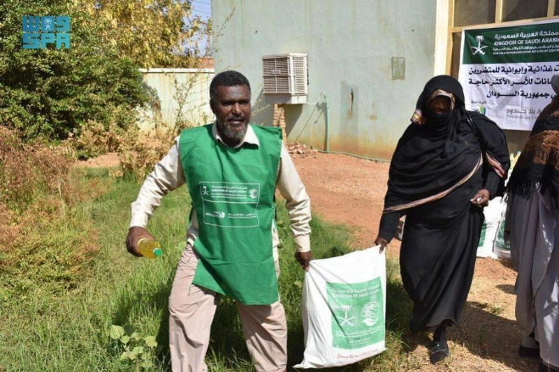 متطوع يساعد سودانية (واس)