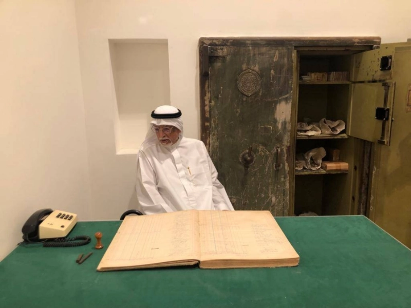صالح صيرفي مسترجعا سجل عملاء المصرف قبل اكثر من سبعين عاما ويظهر خلفة خزائن المصرف لحفظ الاموال