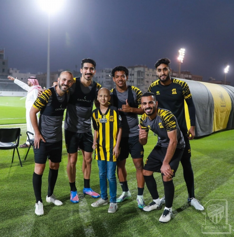 أحد الأطفال مع لاعبي الاتحاد خلال التدريبات (مكة)