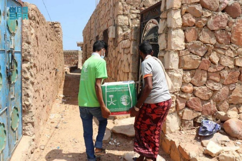 يمنيان يحملان سلة لأحد المنازل في سقطرى (واس)