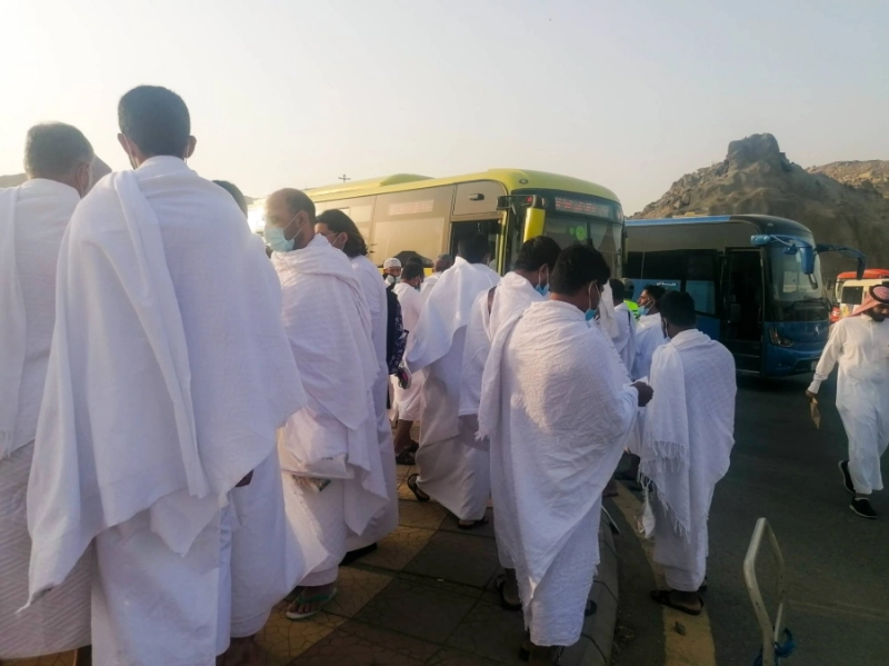 معتمرون في مواقف كدي ينتظرون باصات النقل إلى المسجد الحرام لأداء العمرة ومن ثم العودة إلى المواقف لاستقلال سياراتهم، في تنظيم يساعد
على فك الزحام.