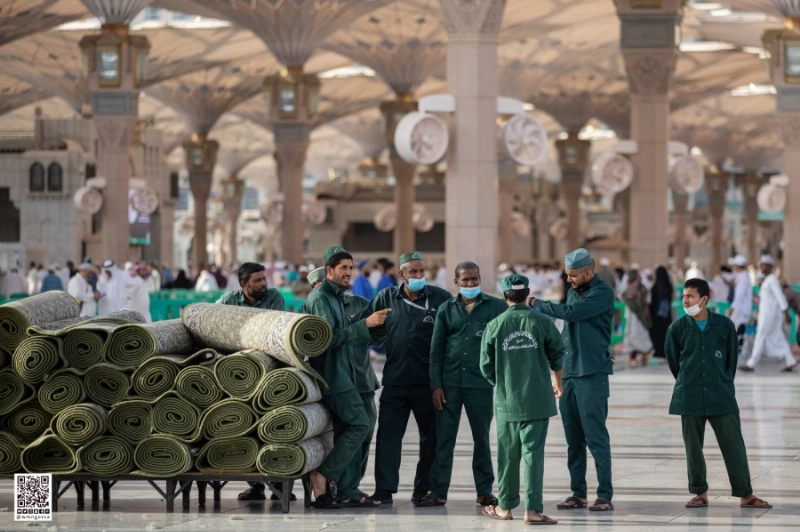 عمال يوزعون السجاد بساحات المسجد النبوي (مكة)