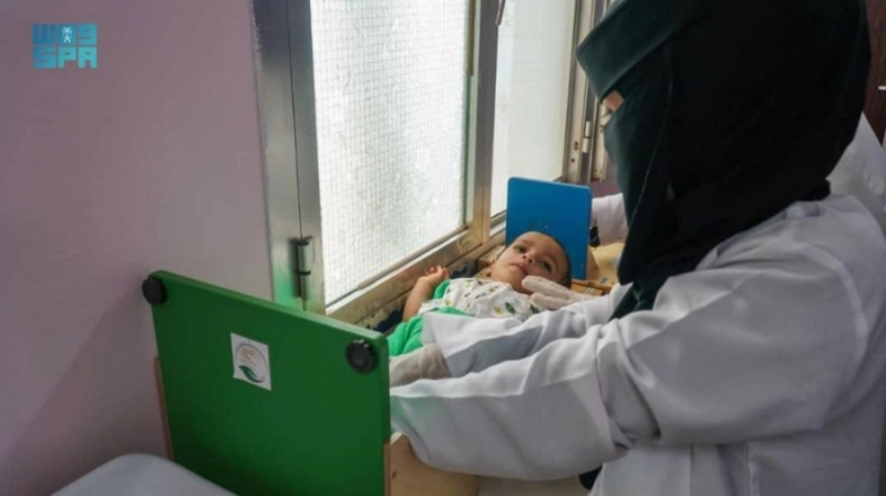 طبيبة تعالج طفلا مصابا بسوء التغذية (واس)