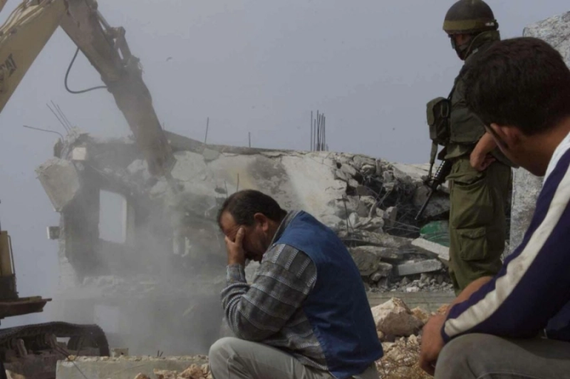 فلسطيني يجلس بينما تهدم سلطات الاحتلال منزله (مكة)