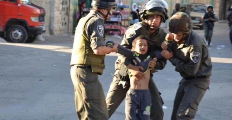 عناصر إسرائيلية تمسك بطفل فلسطيني (مكة)