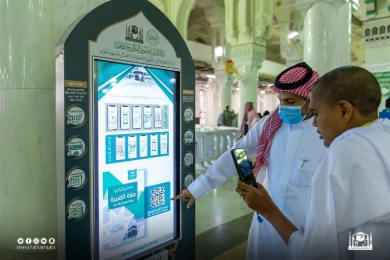 حجاج يتابعون الشاشة التفاعلية (مكة)