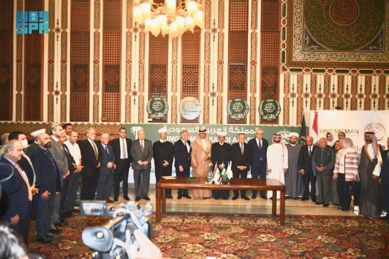 السفير السعودي يتوسط المفتي والمسؤولين وفريق العمل (واس)