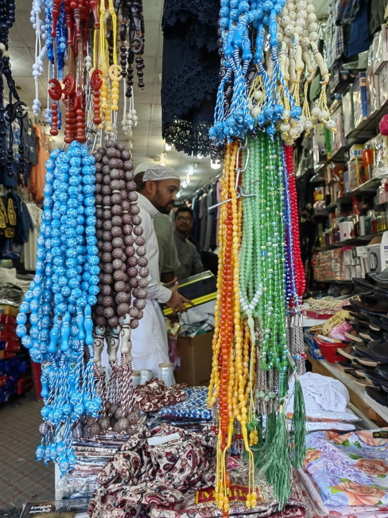 عدد من الحجاج خلال شراء الهدايا قبل المغادرة إلى بلدانهم (أنس الحارثي)