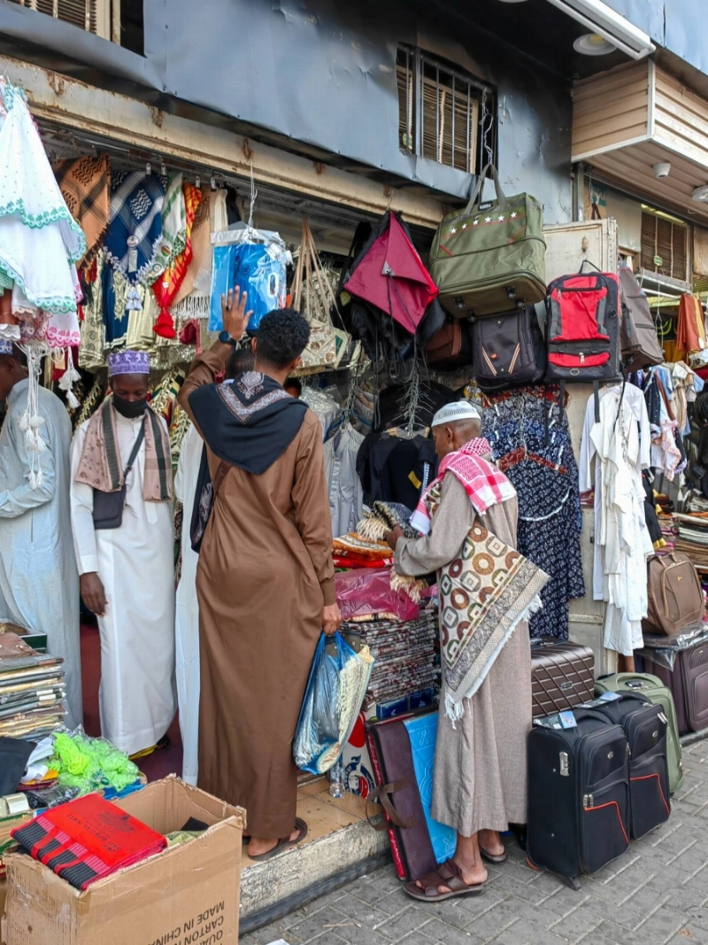 عدد من الحجاج خلال شراء الهدايا قبل المغادرة إلى بلدانهم (أنس الحارثي)