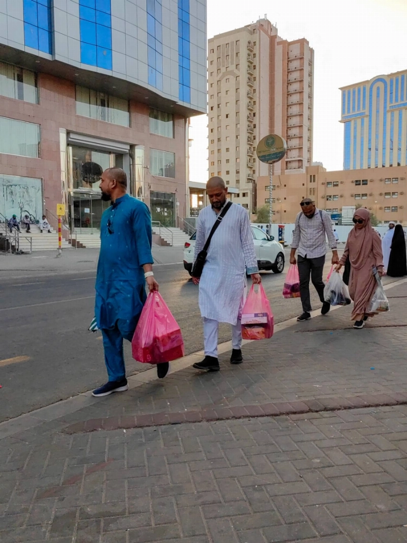 عدد من الحجاج خلال شراء الهدايا قبل المغادرة إلى بلدانهم (أنس الحارثي)