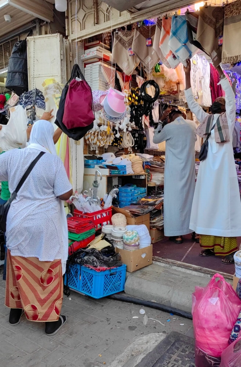 عدد من الحجاج خلال شراء الهدايا قبل المغادرة إلى بلدانهم (أنس الحارثي)