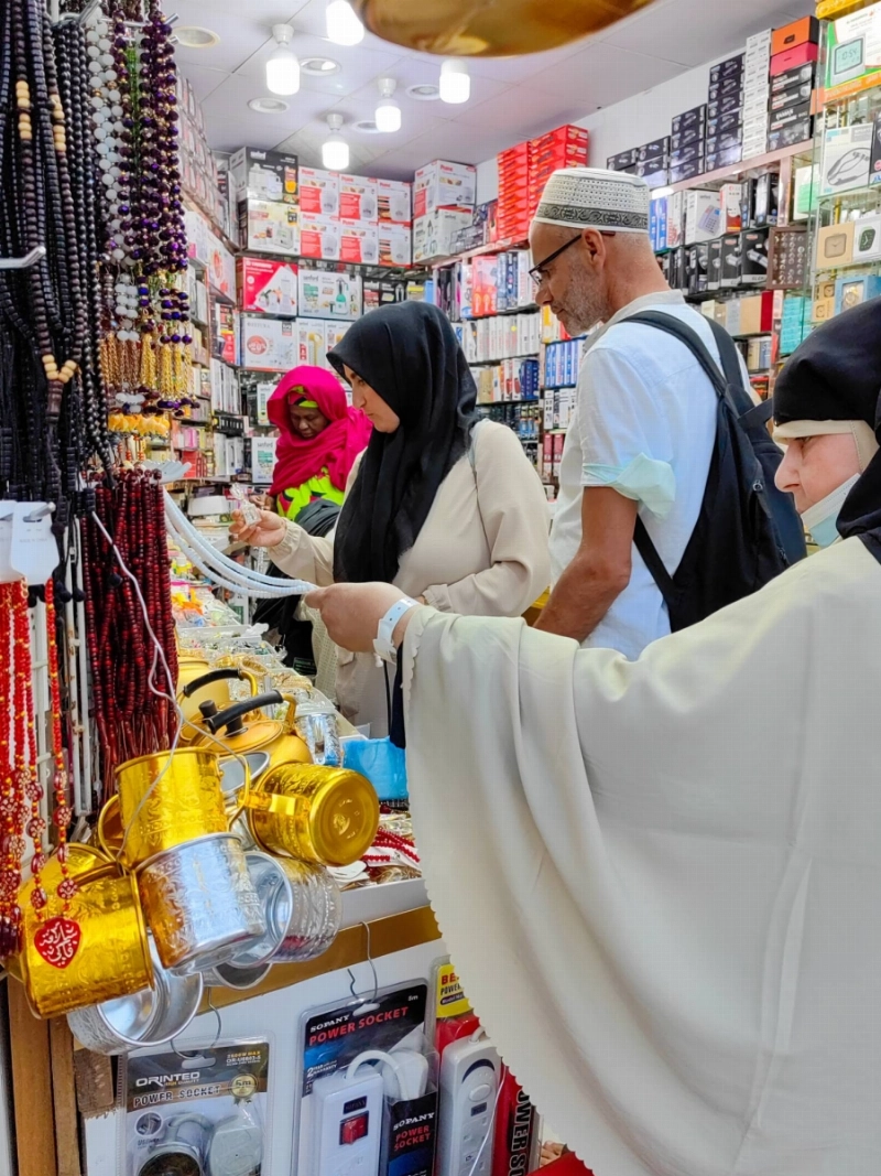 عدد من الحجاج يشترون هدايا قبل مغادرتهم إلى بلدانهم (أنس الحارثي)