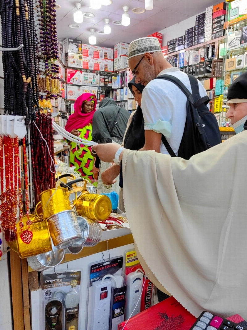 عدد من الحجاج خلال شراء الهدايا قبل المغادرة إلى بلدانهم (أنس الحارثي)