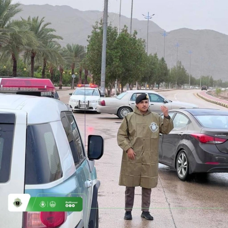 رجل مرور ينظم السير أثناء هطول الأمطار (مكة)