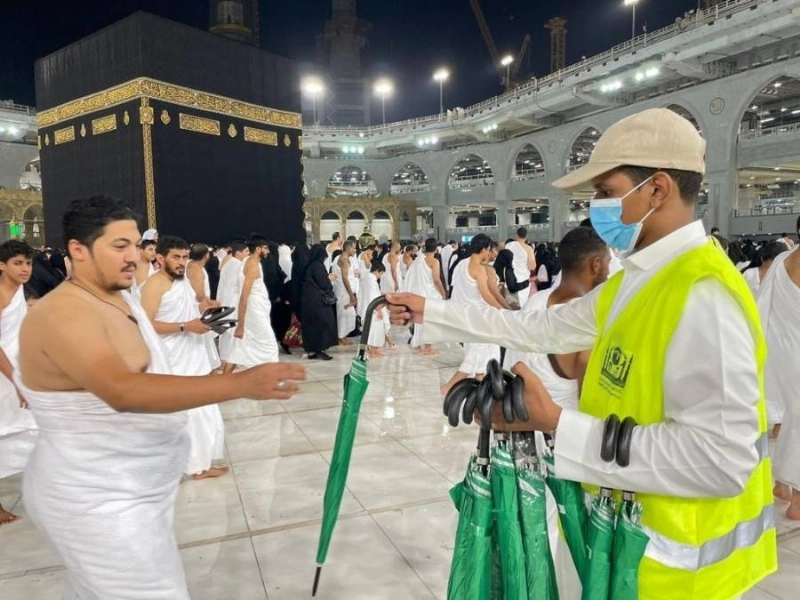 جانب من توزيع المظلات على المعتمرين (مكة)