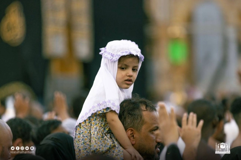 معتمر يحمل طفلته (مكة)