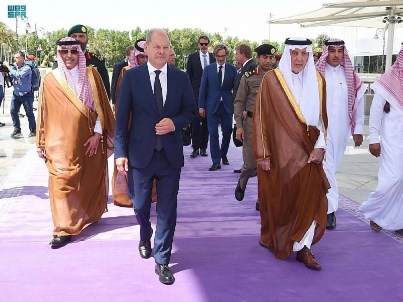 خالد الفيصل مستقبلا المستشار الألماني في المطار