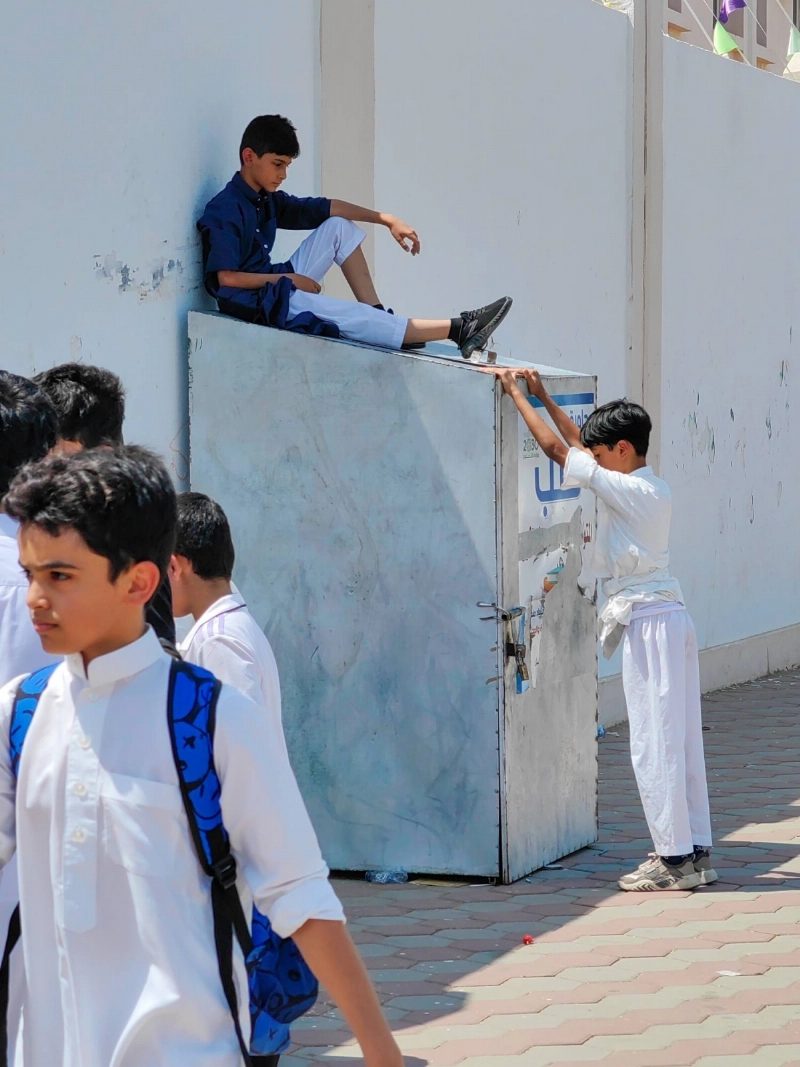 استراحة طالب بعد يوم دراسي، حيث أخذ صندوق تجميع الكتب ليعتليه في استراحة قصيرة، مستظلا من حرارة الشمس بالعاصمة المقدسة. (أنس الحارثي)
