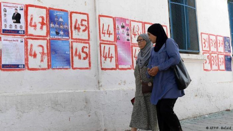 تونسيتان تمران بجوار دعاية انتخابية (مكة)