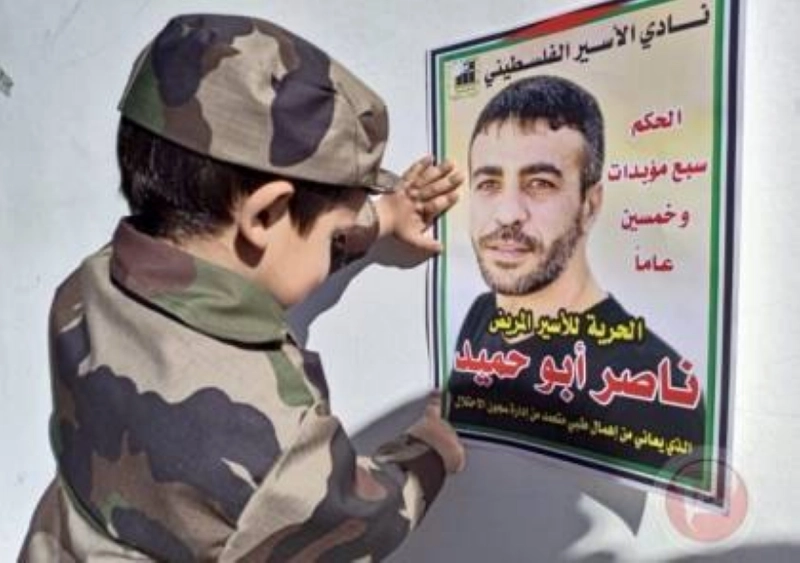 طفل فلسطيني يعلق صورة ناصر أبو حميد (مكة)