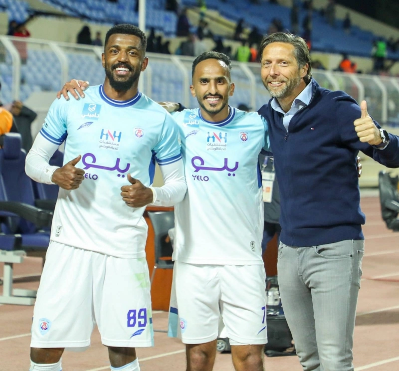 لاعبو أبها والمدرب يحتفلون بالانتصار على العدالة