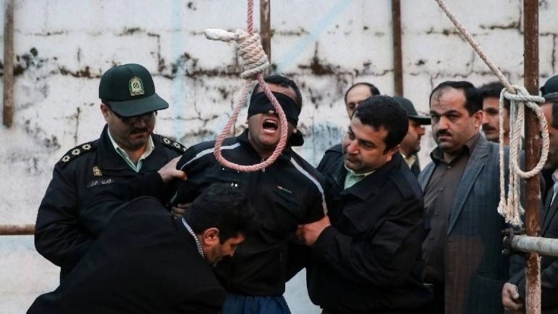عناصر من النظام يستعدون لتقديم شاب لمقصلة الإعدام (مكة)