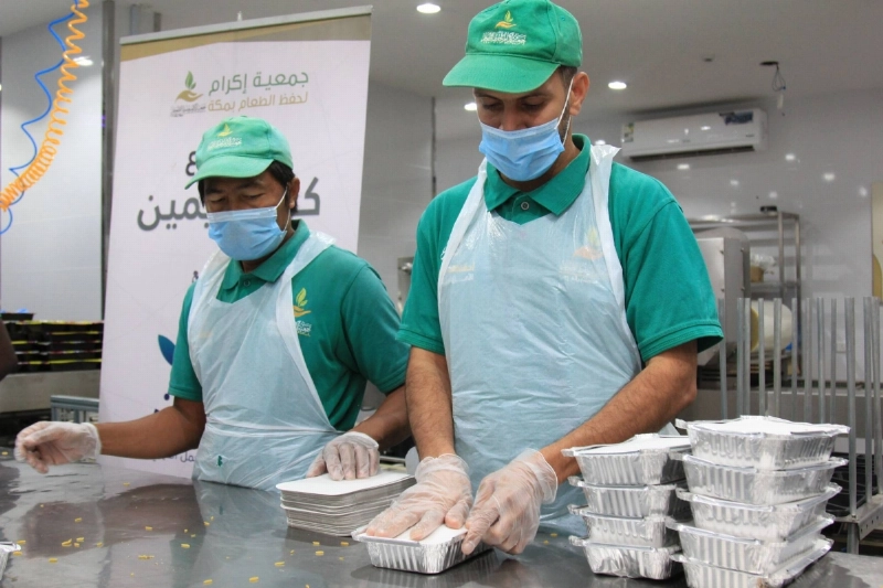 عاملان خلال تجهيز فائض الطعام (مكة)