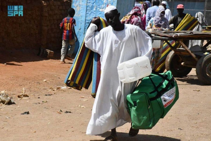 سوداني يحمل إحدى الحقائب الإيوائية السعودية (واس)