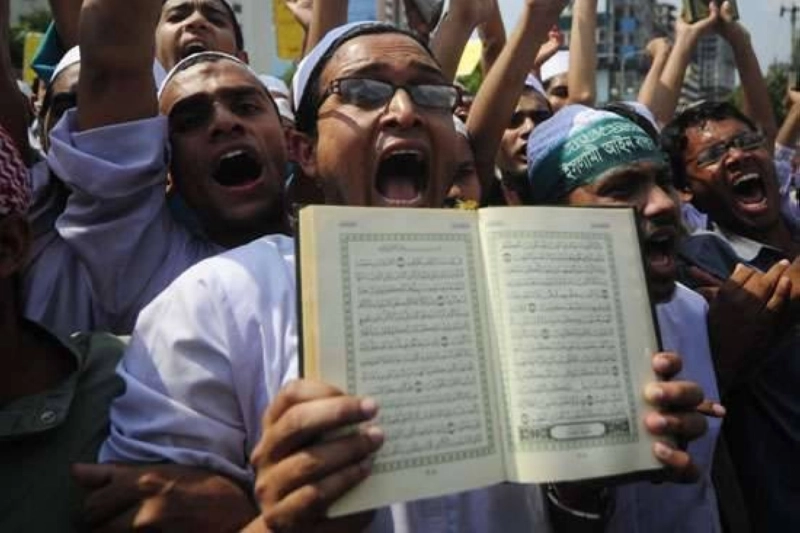 مسلم يرفع القرأن الكريم في مواجهة المتطرفين (مكة)