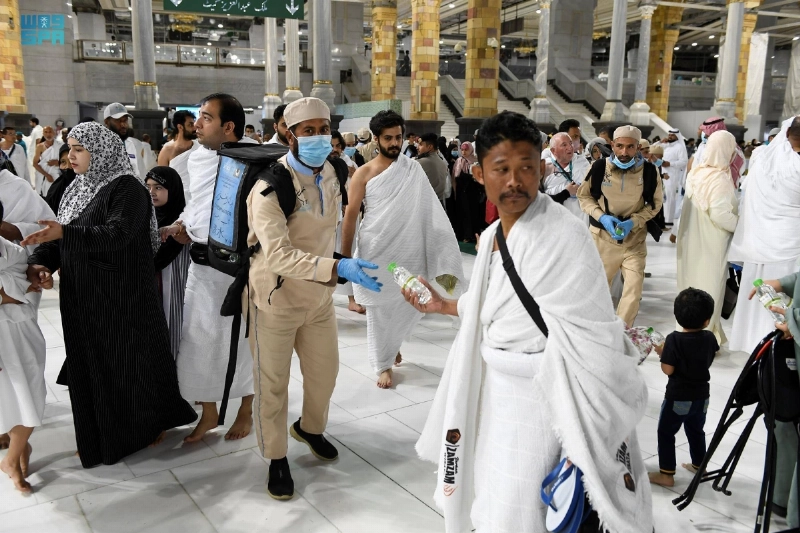 العمال يوزعون ماء زمزم على المعتمرين (مكة)