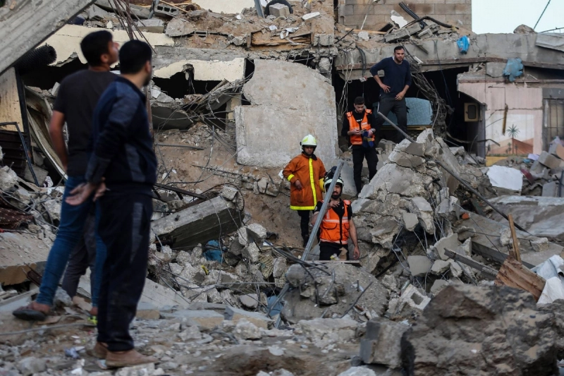 فلسطينيون وعمال طوارئ يفتشون أنقاض مبنى دمرته اسرائيل (د ب أ)