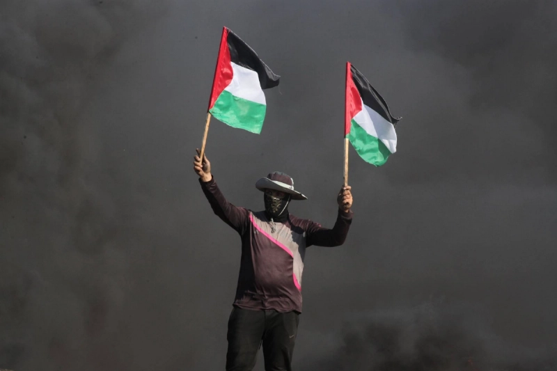 فلسطيني يرفع علم بلاده